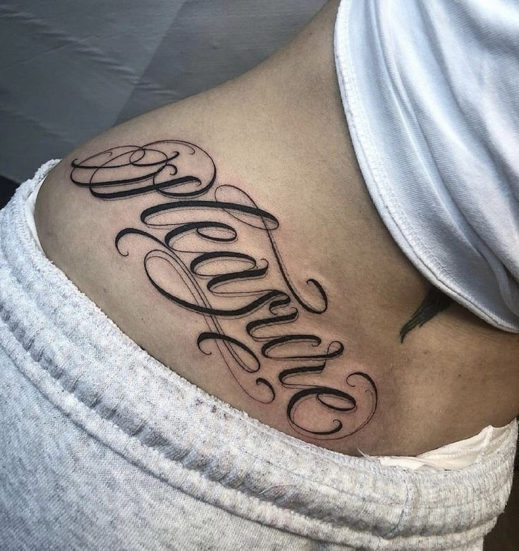 Hình xăm chữ “Feminine” (Nữ tính) với phông chữ mềm mại, thể hiện vẻ đẹp dịu dàng và nữ tính.