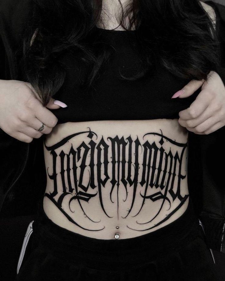 Hình xăm chữ tiếng Latin “Memento Mori” (Hãy nhớ rằng ngươi sẽ chết) trên bụng, nhắc nhở về sự hữu hạn của cuộc sống và trân trọng từng khoảnh khắc.