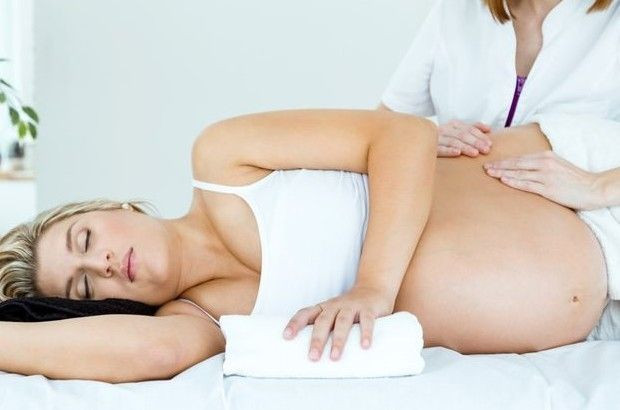 Kỹ thuật viên đang massage lưng cho thai phụ
