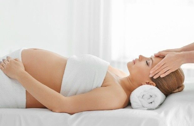 Một thai phụ đang được massage chân bởi kỹ thuật viên