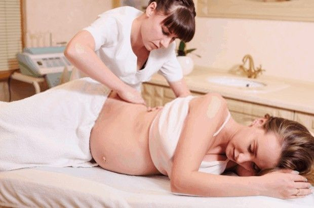 Một thai phụ đang nằm trên giường massage được chuẩn bị chuyên dụng